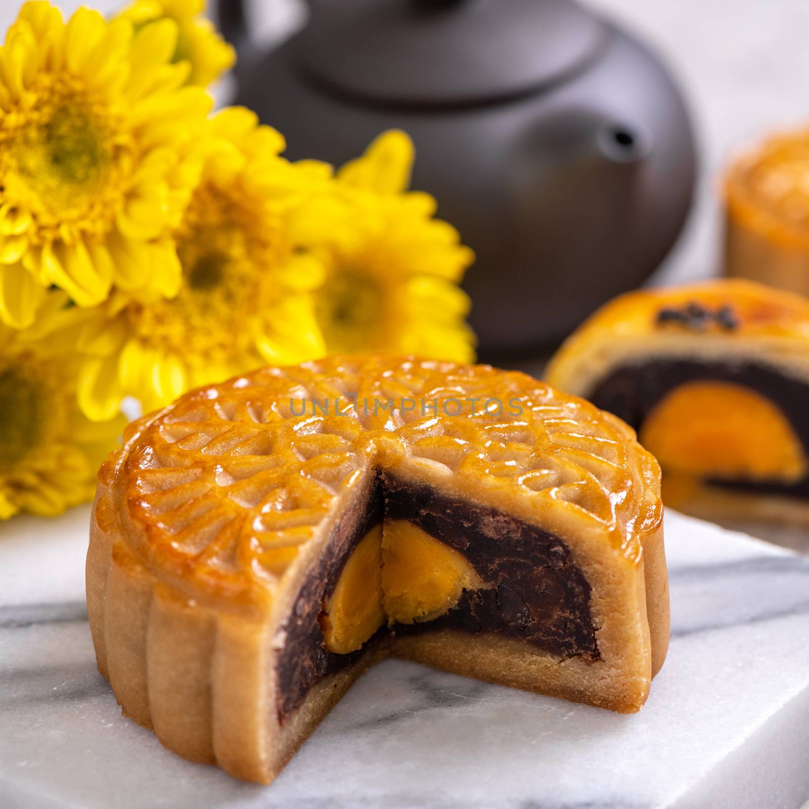 Tasty baked egg yolk pastry moon cake for Mid-Autumn Festival on bright cement table background. Chinese traditional food concept, close up, copy space.
