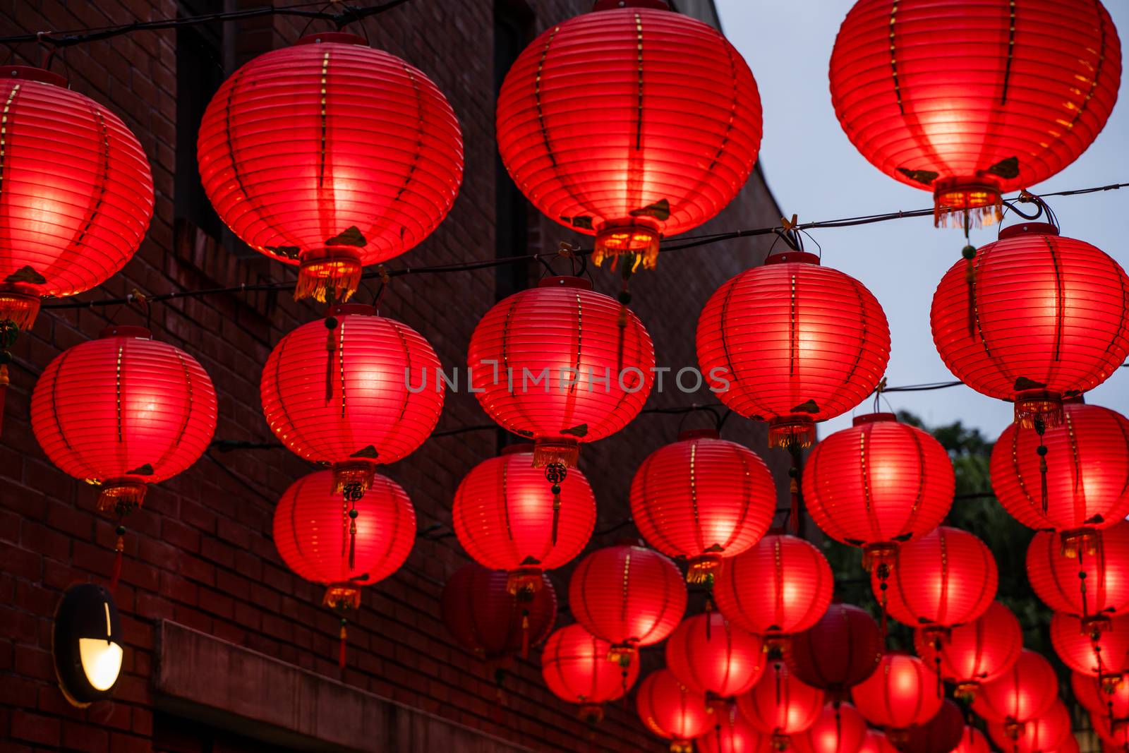 Beautiful round red lantern hanging on old traditional street, concept of Chinese lunar new year festival in Taiwan, close up. The undering word means blessing.