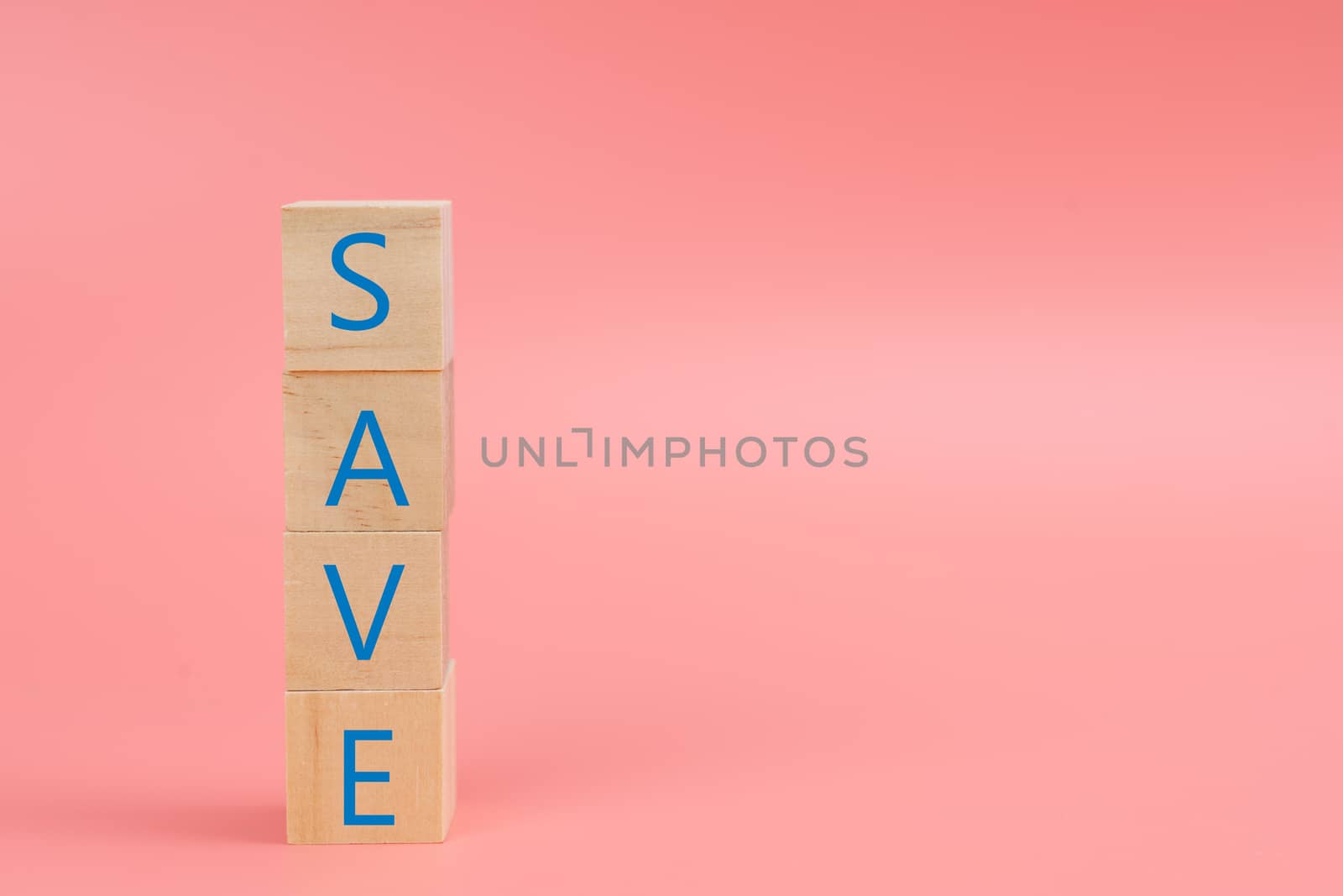 The word SAVE on the wood block on pink background