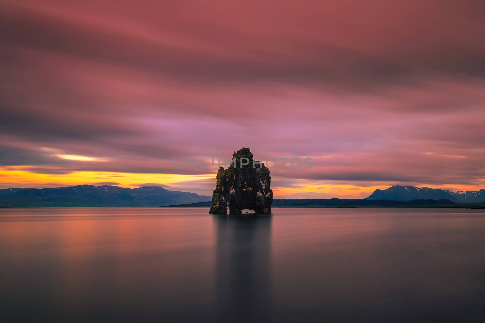 Colorful sunset at the Hvitserkur basalt stack in northern Iceland. Hvitserkur is a spectacular rock in a shape of a dragon or dinosaur drinking water from the ocean. Long exposure.
