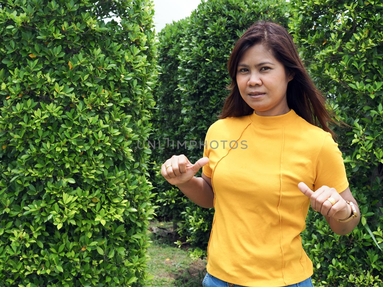 Asian women wearing yellow shirts With a finger pointing.