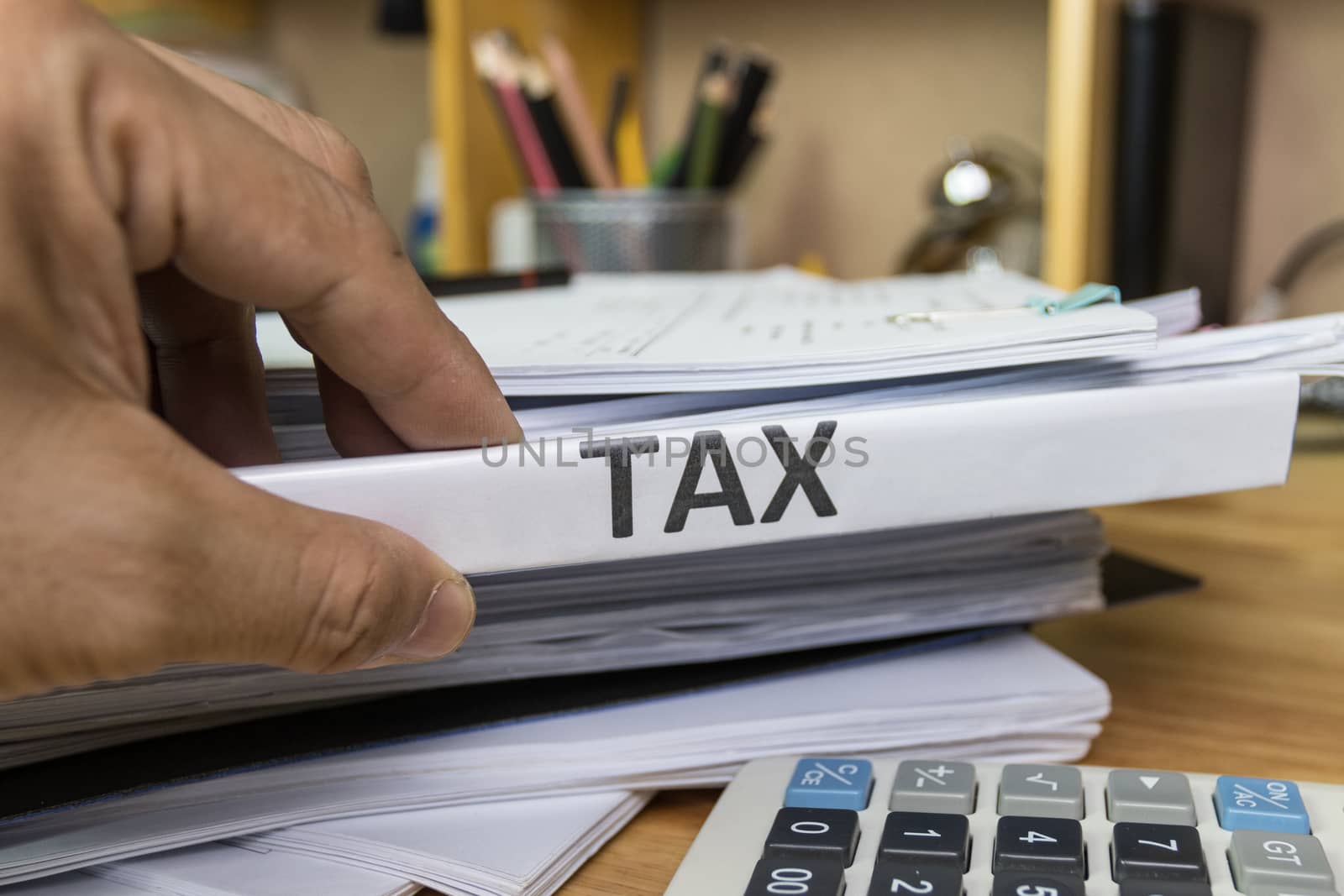 Hand of Man search and hold Tax Files folder at office 