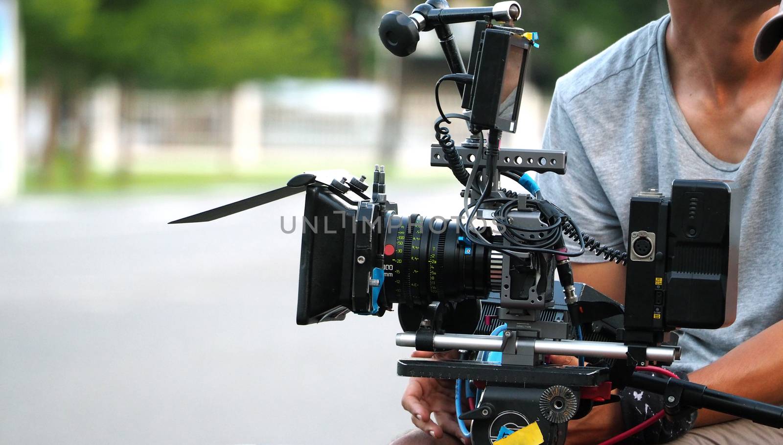 Behind the scenes of movie shooting or video production and film crew team with camera equipment at outdoor location.