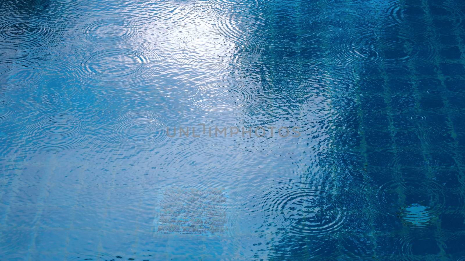 Rain drop on the surface of swiming pool water and have a ripple wave effect texture. 