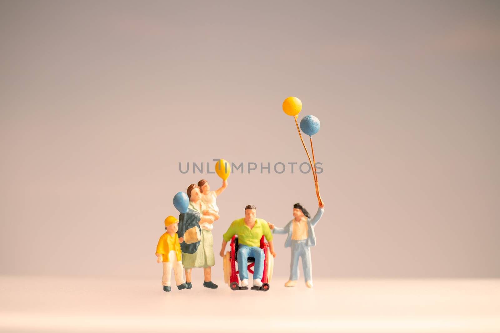 Miniature people Positive family taking care of their disabled Father