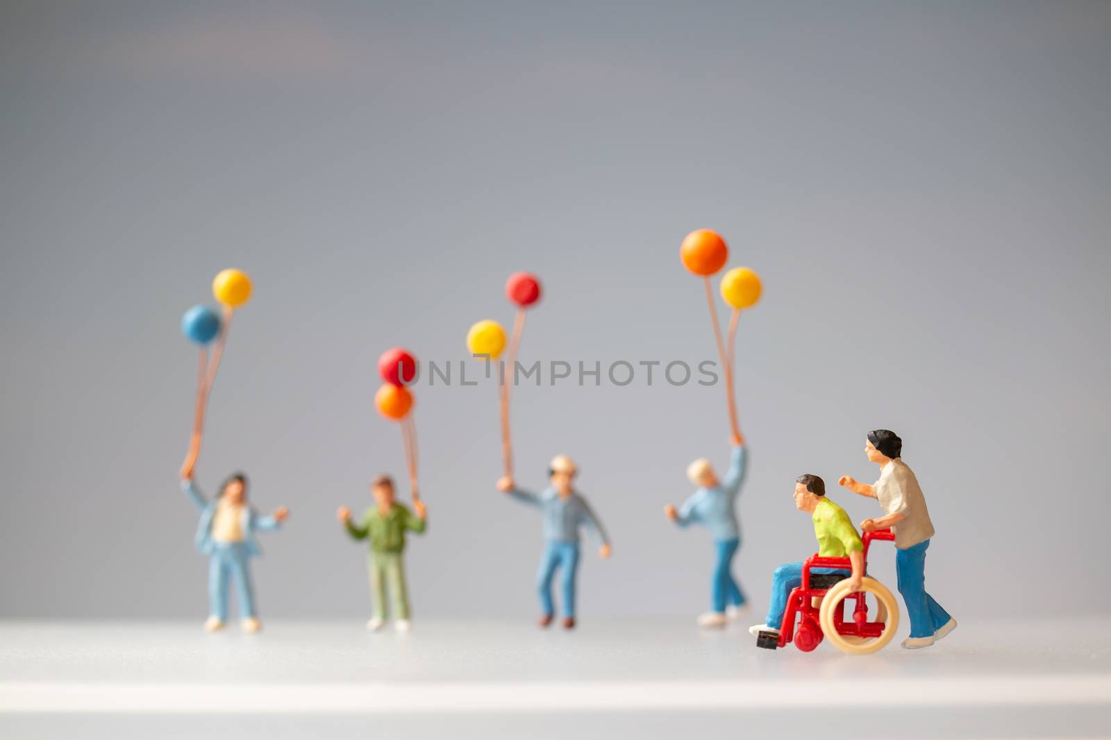 Miniature people Positive family taking care of their disabled Father