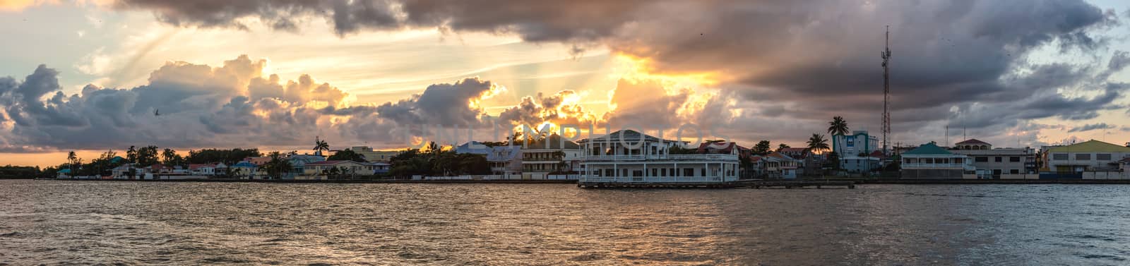 Beautiful panoramic shot of Belize city at sunset. Amazing orange sky and clouds in the background.