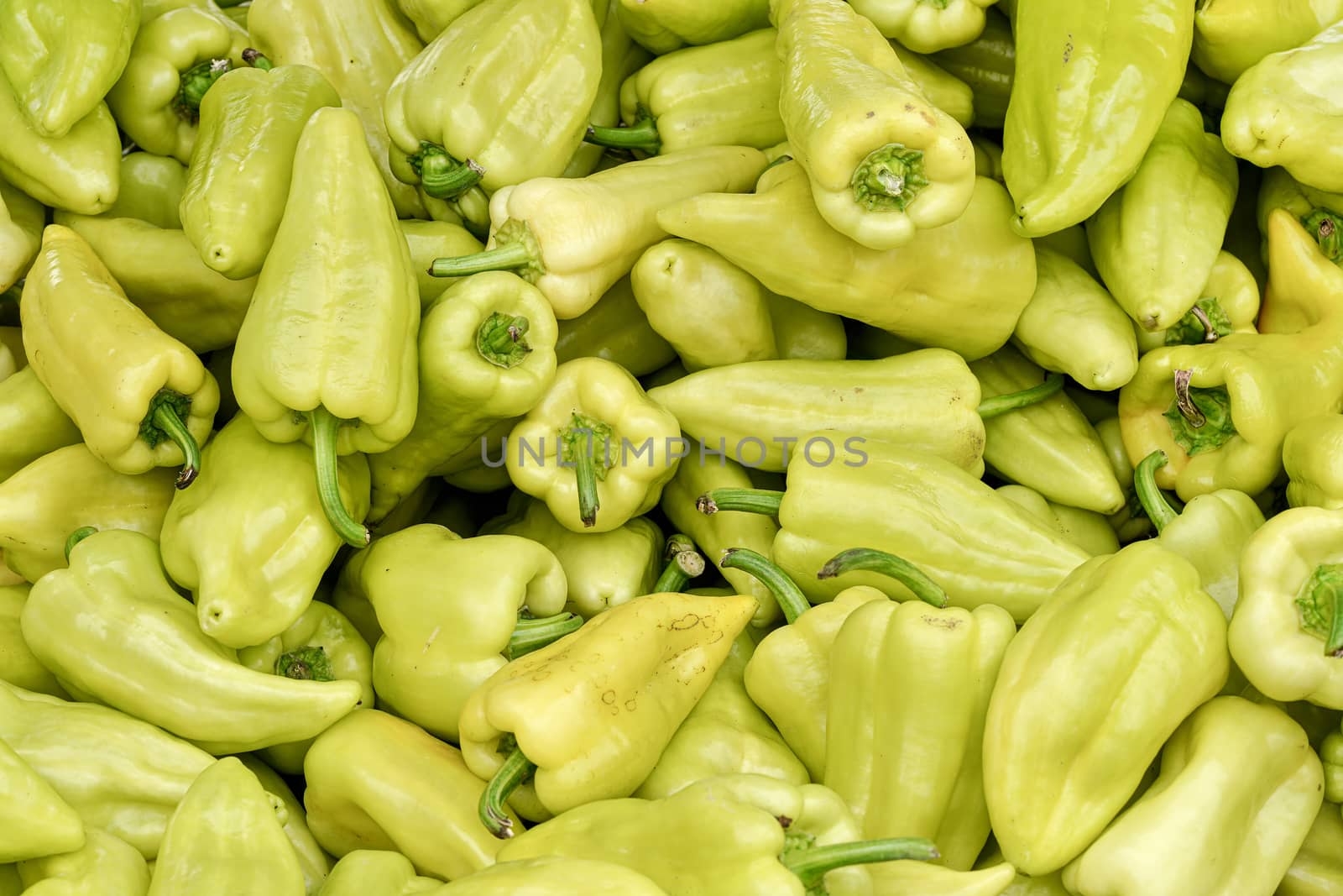 Heap of pointed sweet white bell peppers displayed on food market, closeup detail by Ivanko