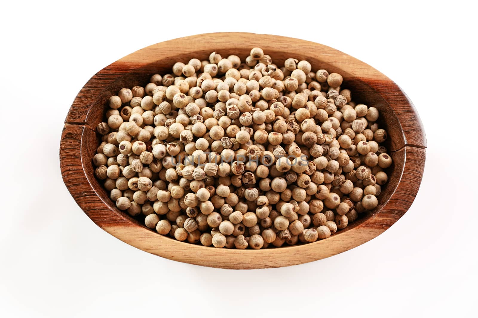 Dried white pepper corns in small wooden bowl - view form above isolated on white background by Ivanko