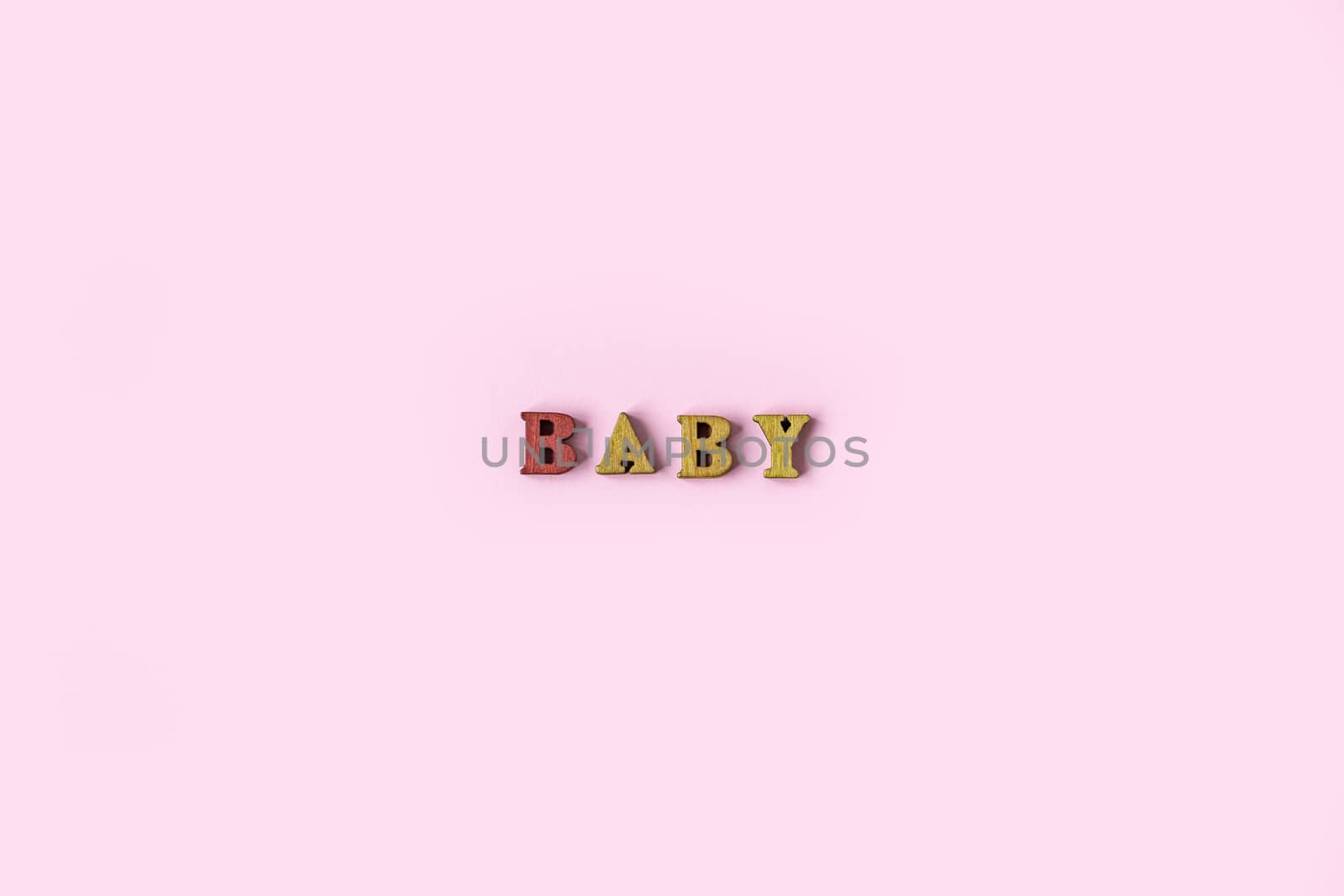 The word BABY is made of wooden letters on a pale pink background. Banner design. Baby shower concept. Photo of minimal background with beeautiful decor and place for text isolated pink background by Pirlik