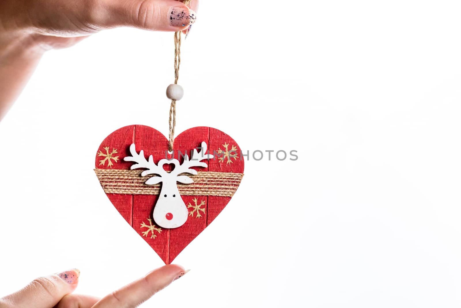 Hand holding heart shaped Christmas decoration isolated on white by vladispas