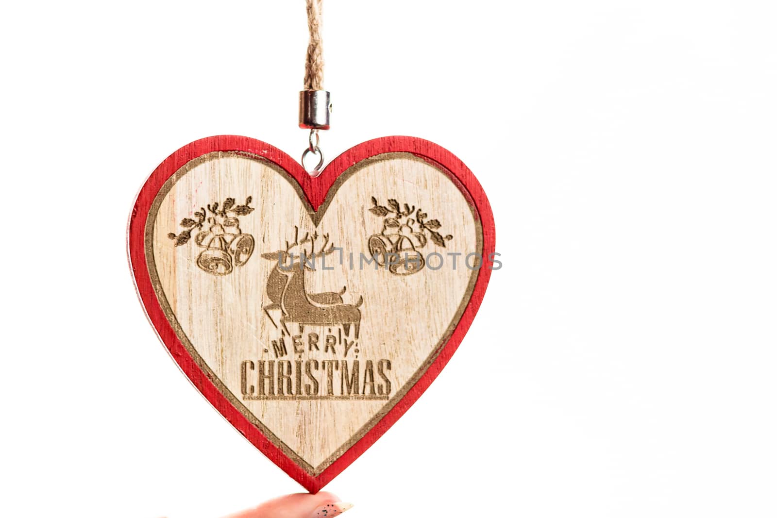Hand holding heart shaped Christmas decoration isolated on white by vladispas