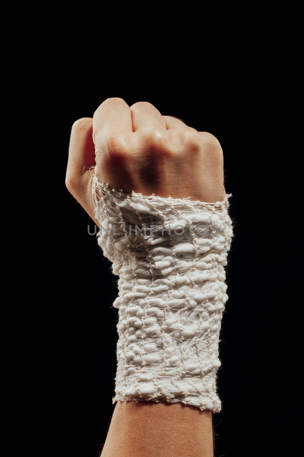 wrist wrapped with healing bandage, isolated on black