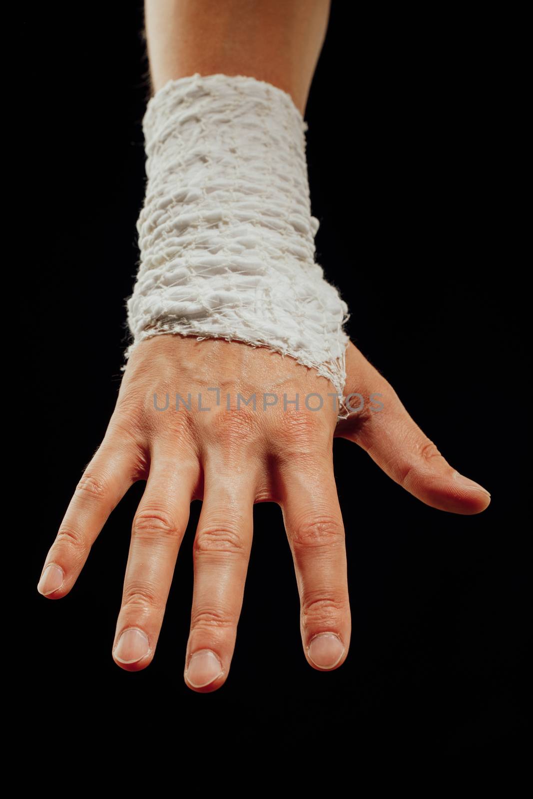 wrist wrapped with healing bandage, isolated on black