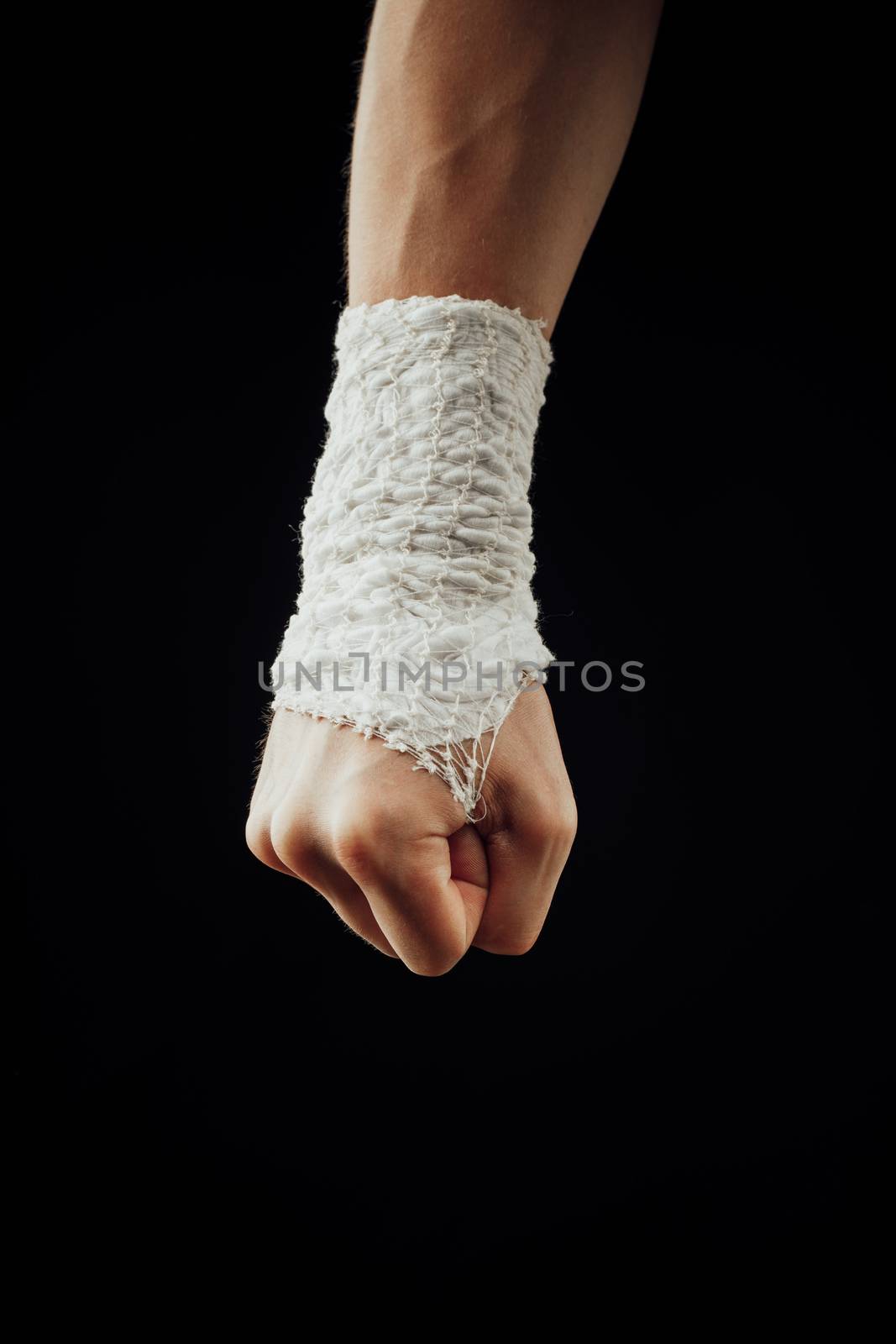 wrist wrapped with healing bandage, isolated on black