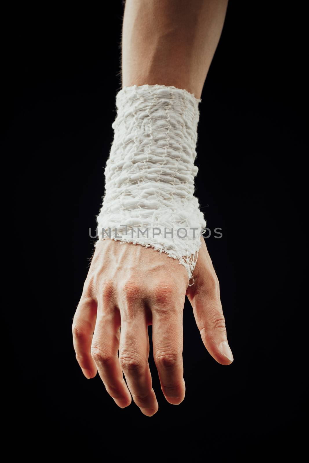 wrist wrapped with healing bandage, isolated on black