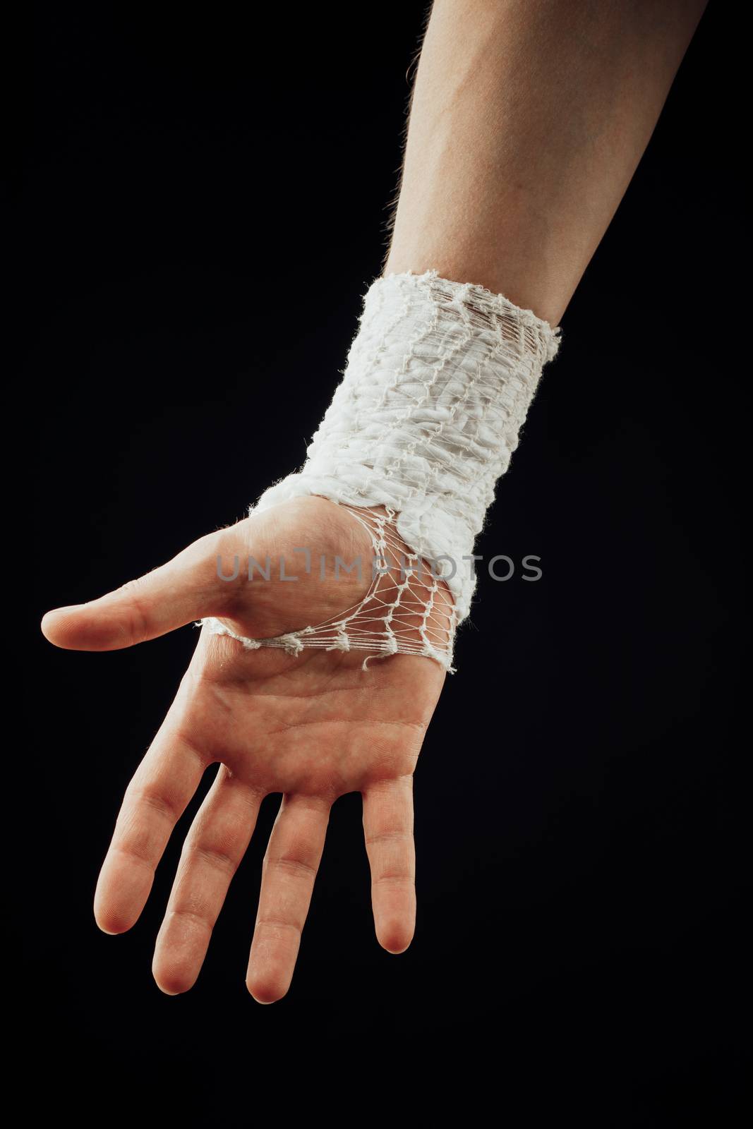 wrist wrapped with healing bandage, isolated on black