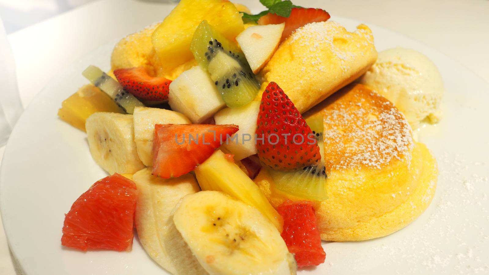 Japanese pancake and many kind of fruits include banana strawberry kiwi orange and serve with ice-cream.