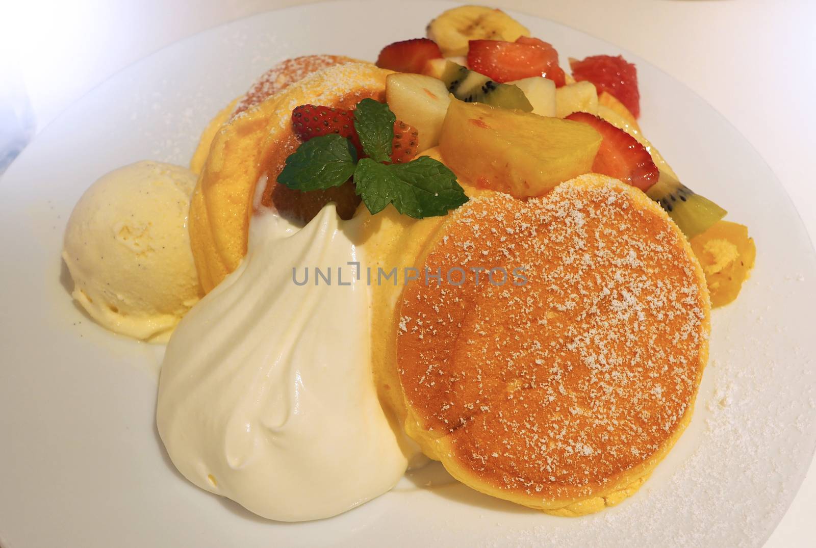 Japanese pancake and many kind of fruits include banana strawberry kiwi orange and serve with ice-cream.