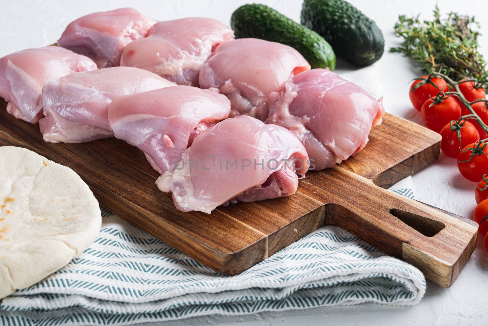 Shawarma ingredients, chicken thighs on white background.