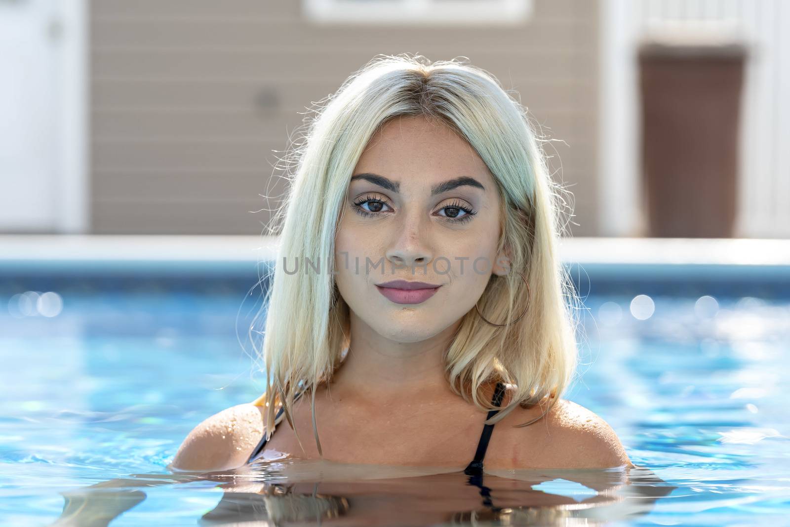 A gorgeous young blonde model poses in a bikini while enjoying a summers day