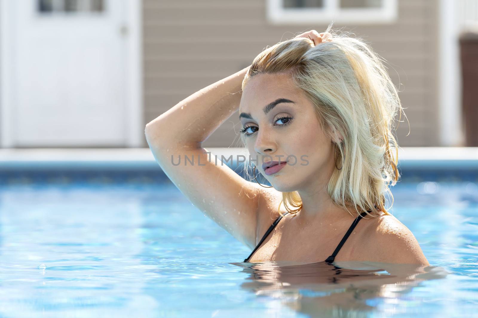 A gorgeous young blonde model poses in a bikini while enjoying a summers day