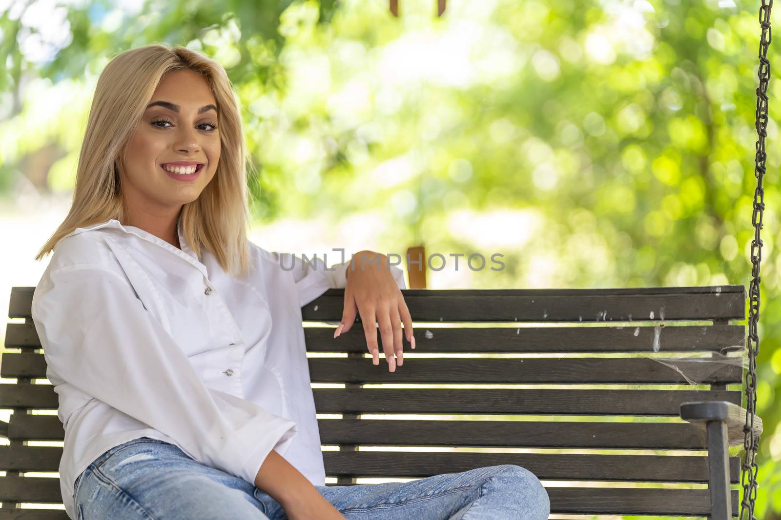 A gorgeous young blonde model poses outdoors while enjoying a summers day