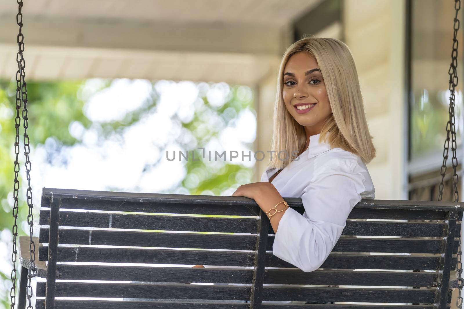 A gorgeous young blonde model poses outdoors while enjoying a summers day
