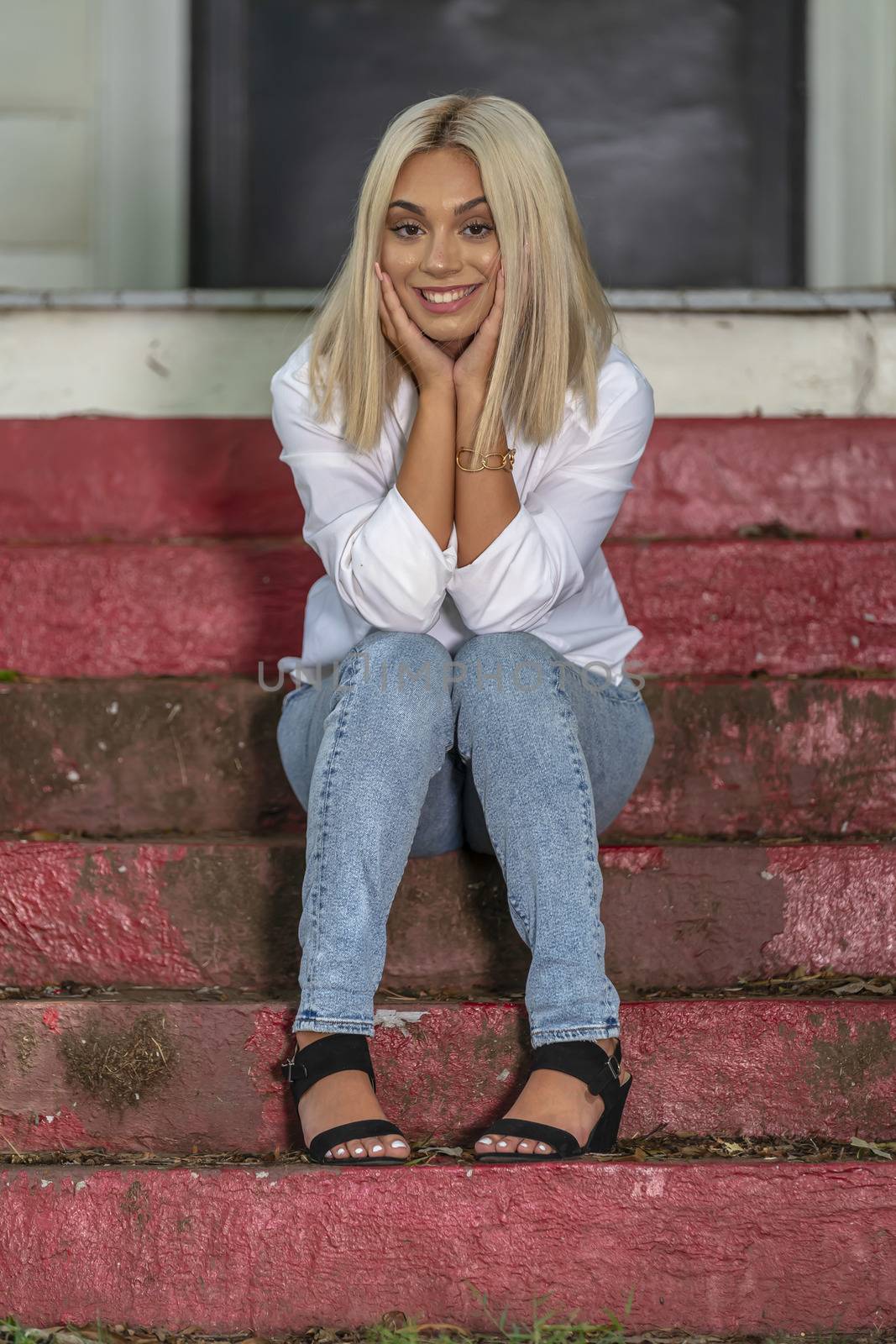 A gorgeous young blonde model poses outdoors while enjoying a summers day