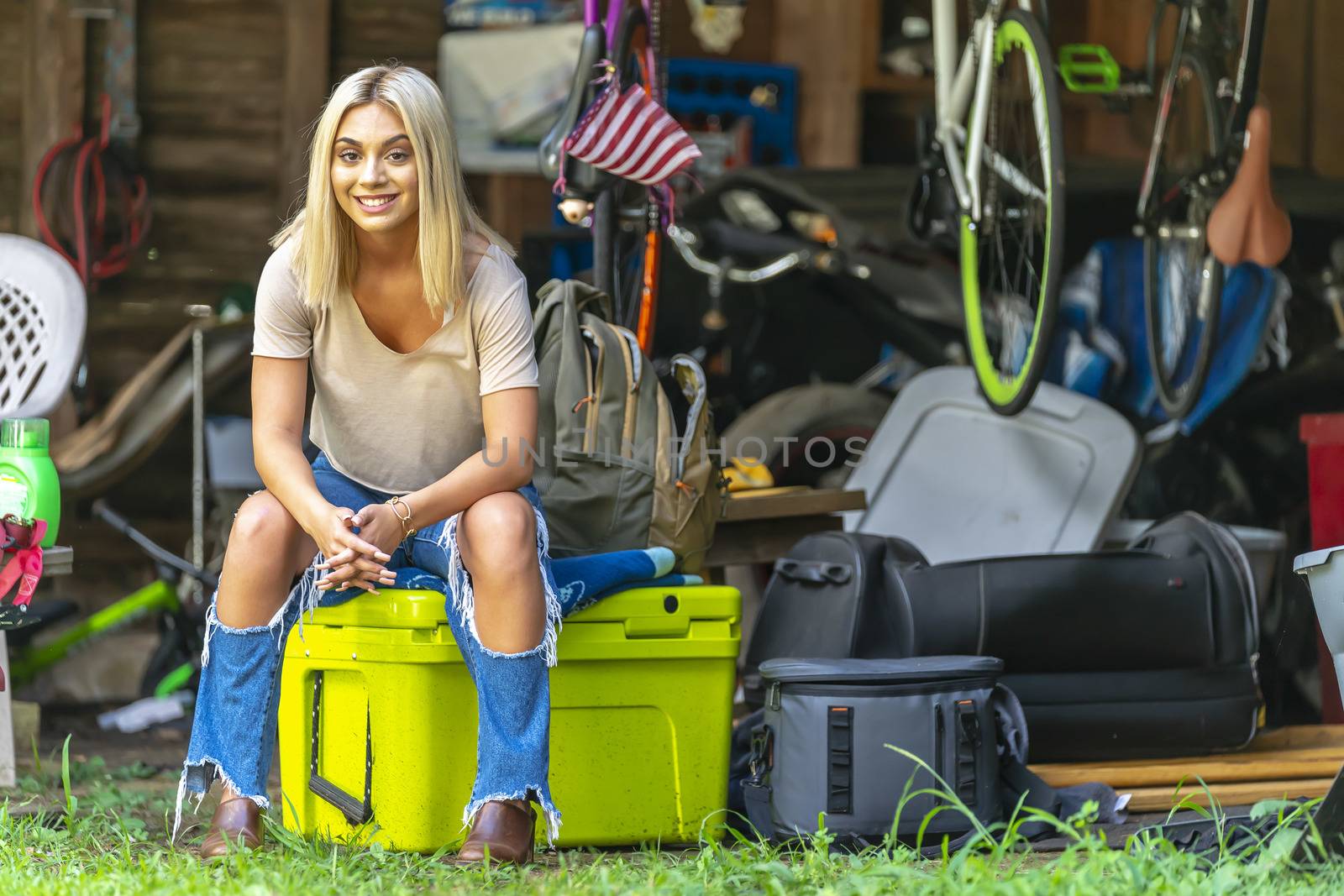 A gorgeous young blonde model poses outdoors while enjoying a summers day