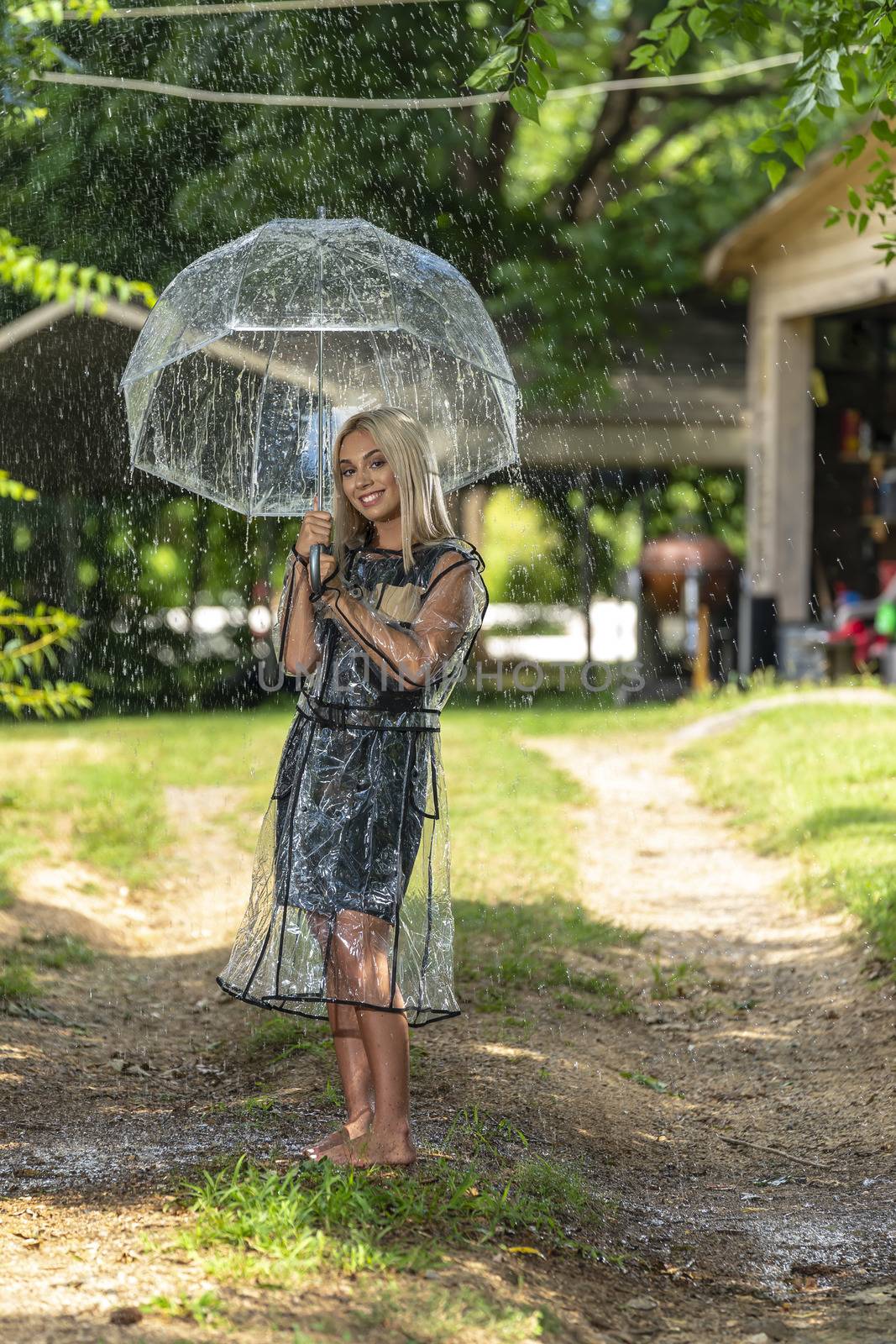 A gorgeous young blonde model poses while getting wet outdoors as she enjoys a summers day