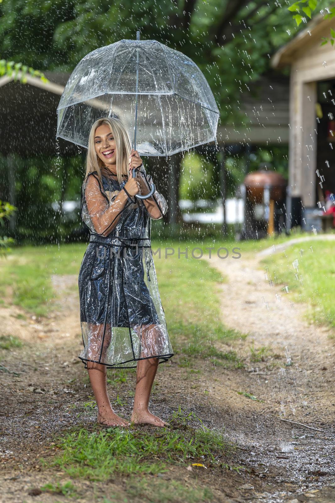 A gorgeous young blonde model poses while getting wet outdoors as she enjoys a summers day