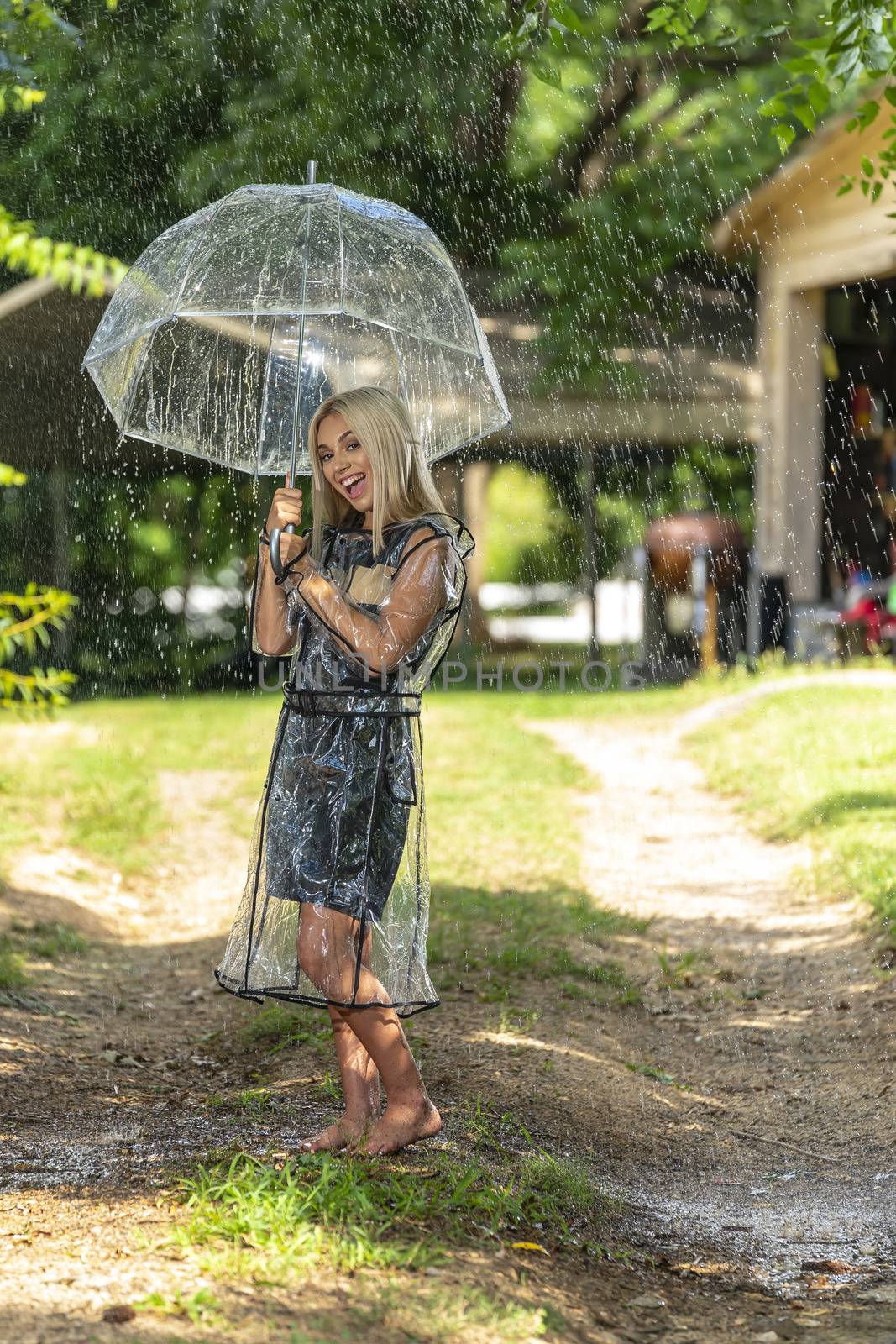 A gorgeous young blonde model poses while getting wet outdoors as she enjoys a summers day