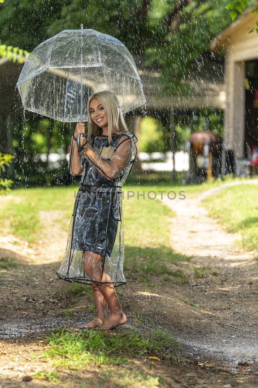 A gorgeous young blonde model poses while getting wet outdoors as she enjoys a summers day