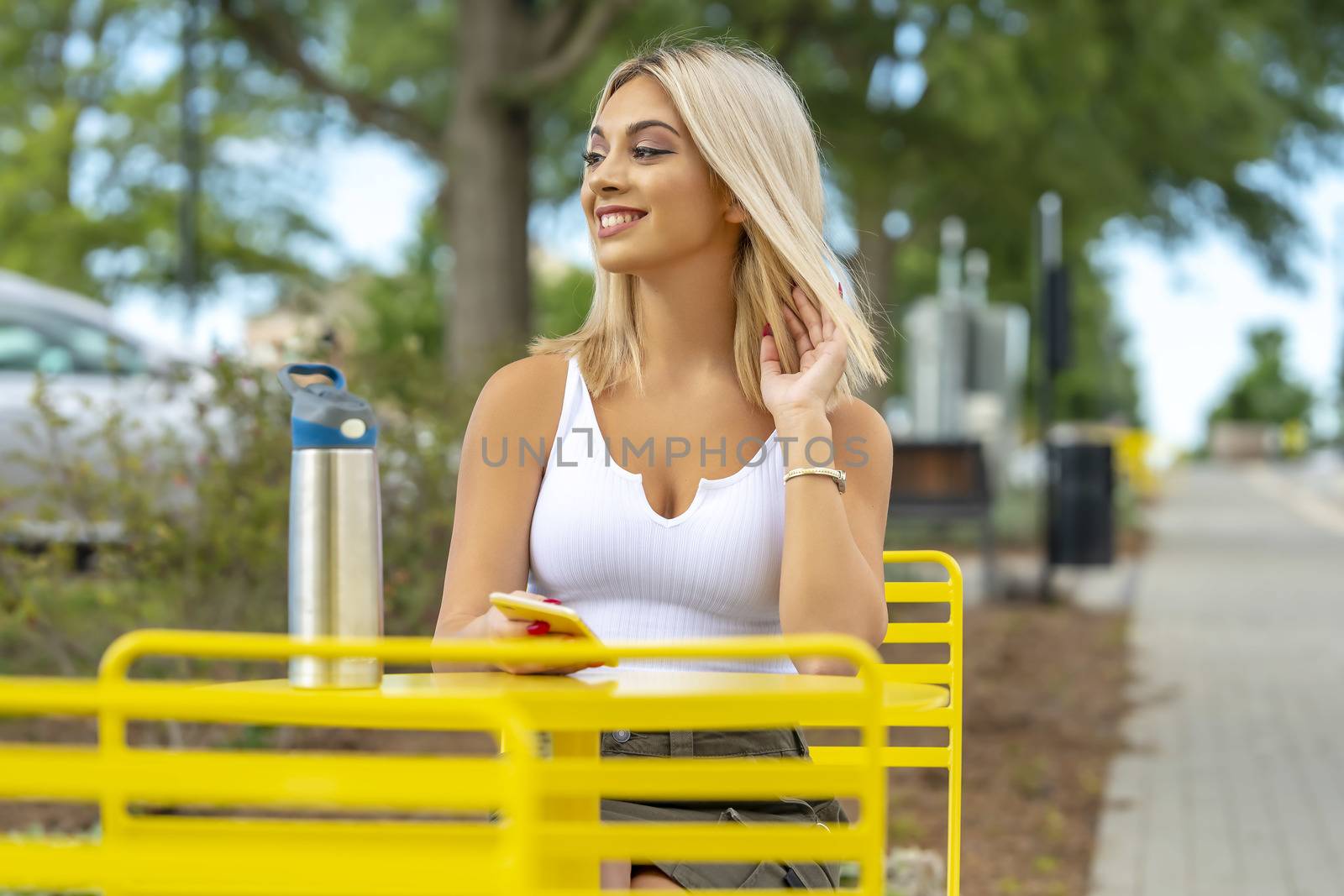 A gorgeous young blonde model poses outdoors while enjoying a summers day