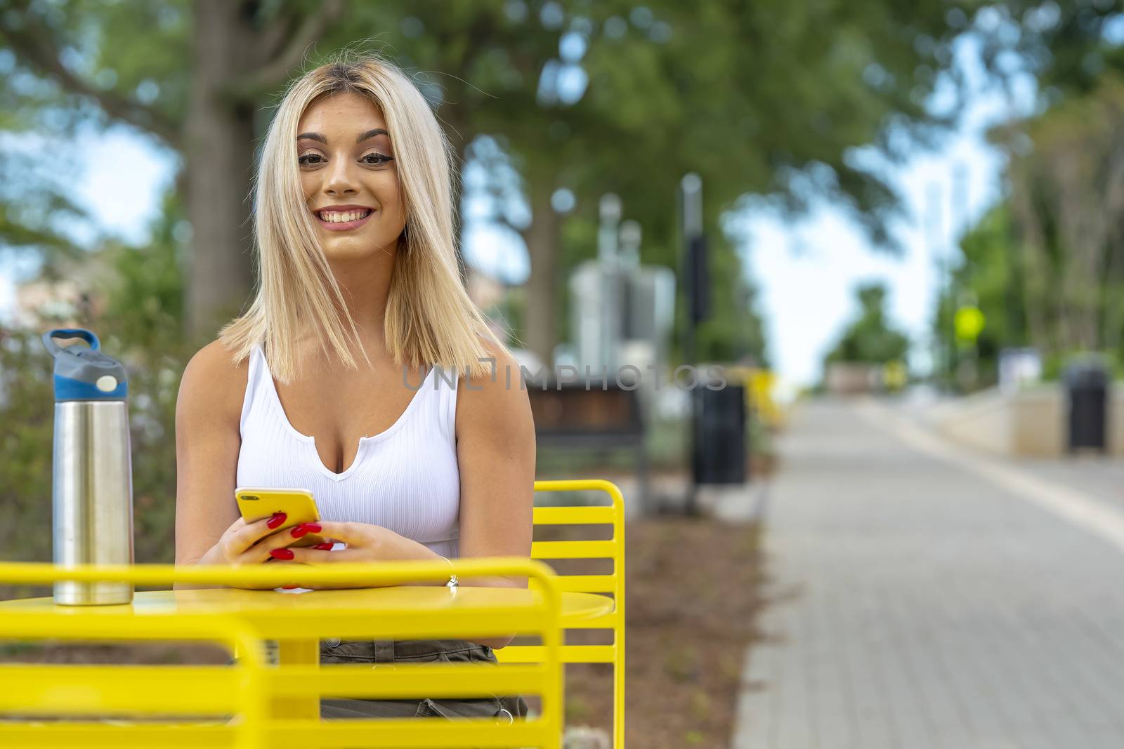 A gorgeous young blonde model poses outdoors while enjoying a summers day