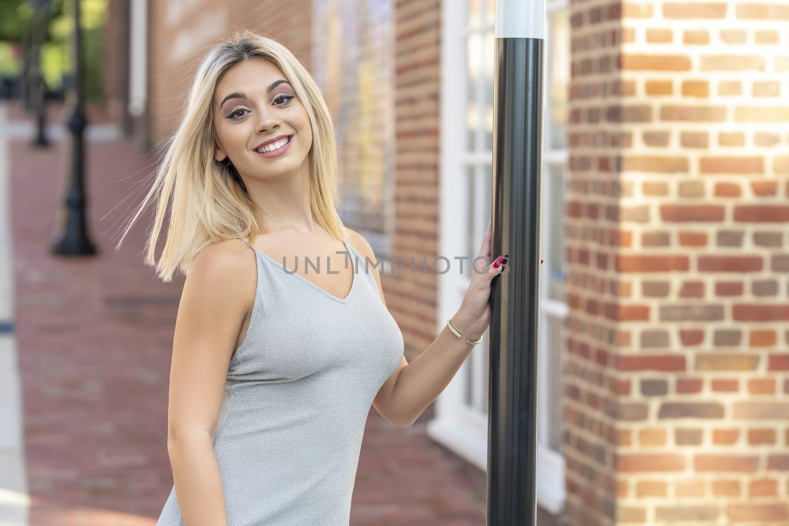 A gorgeous young blonde model poses outdoors while enjoying a summers day
