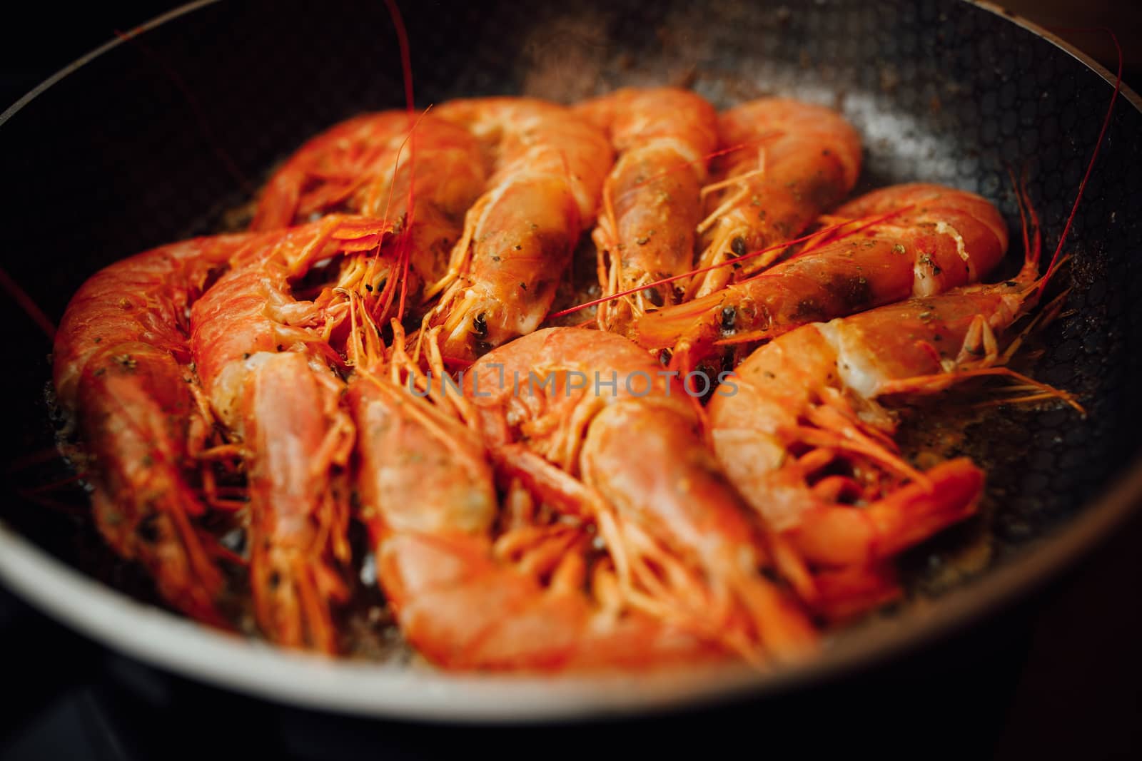 fried red shrimps with hot oil on pan by nikkytok