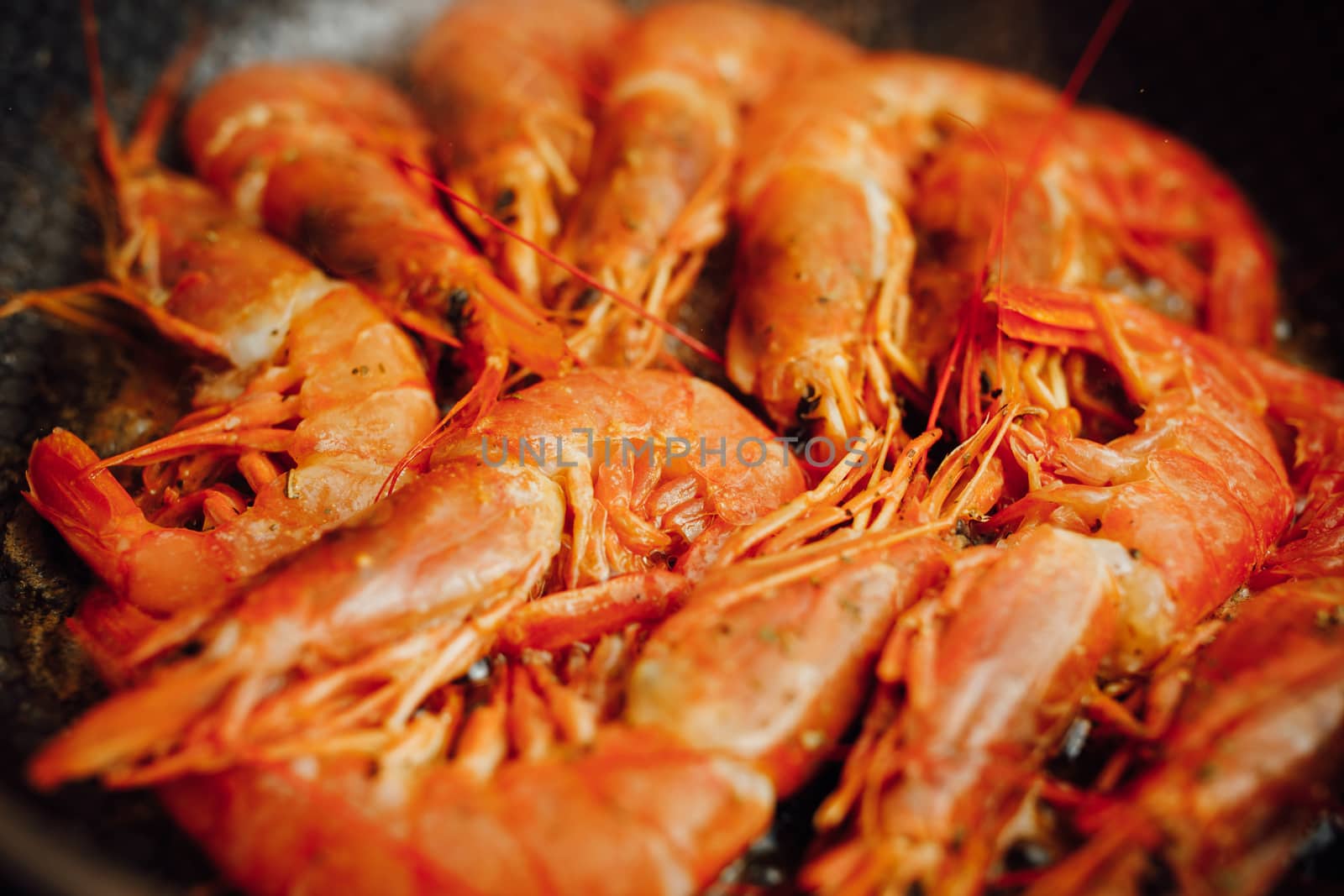 fried red shrimps with hot oil on pan by nikkytok