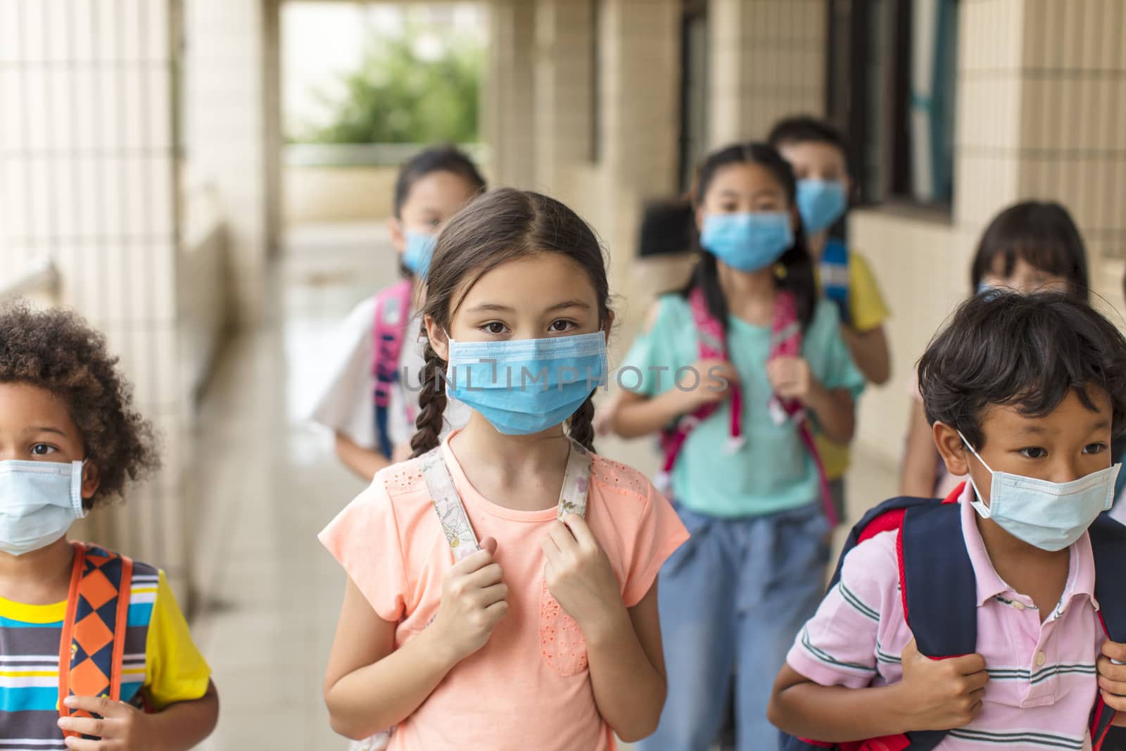 children wearing face medical mask back to school after covid-19 quarantine by tomwang