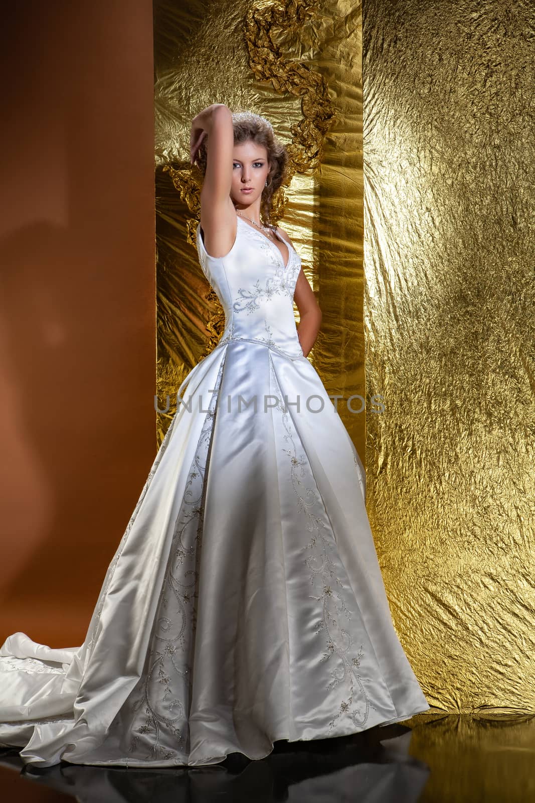 Young woman in a wedding dress on a studio background