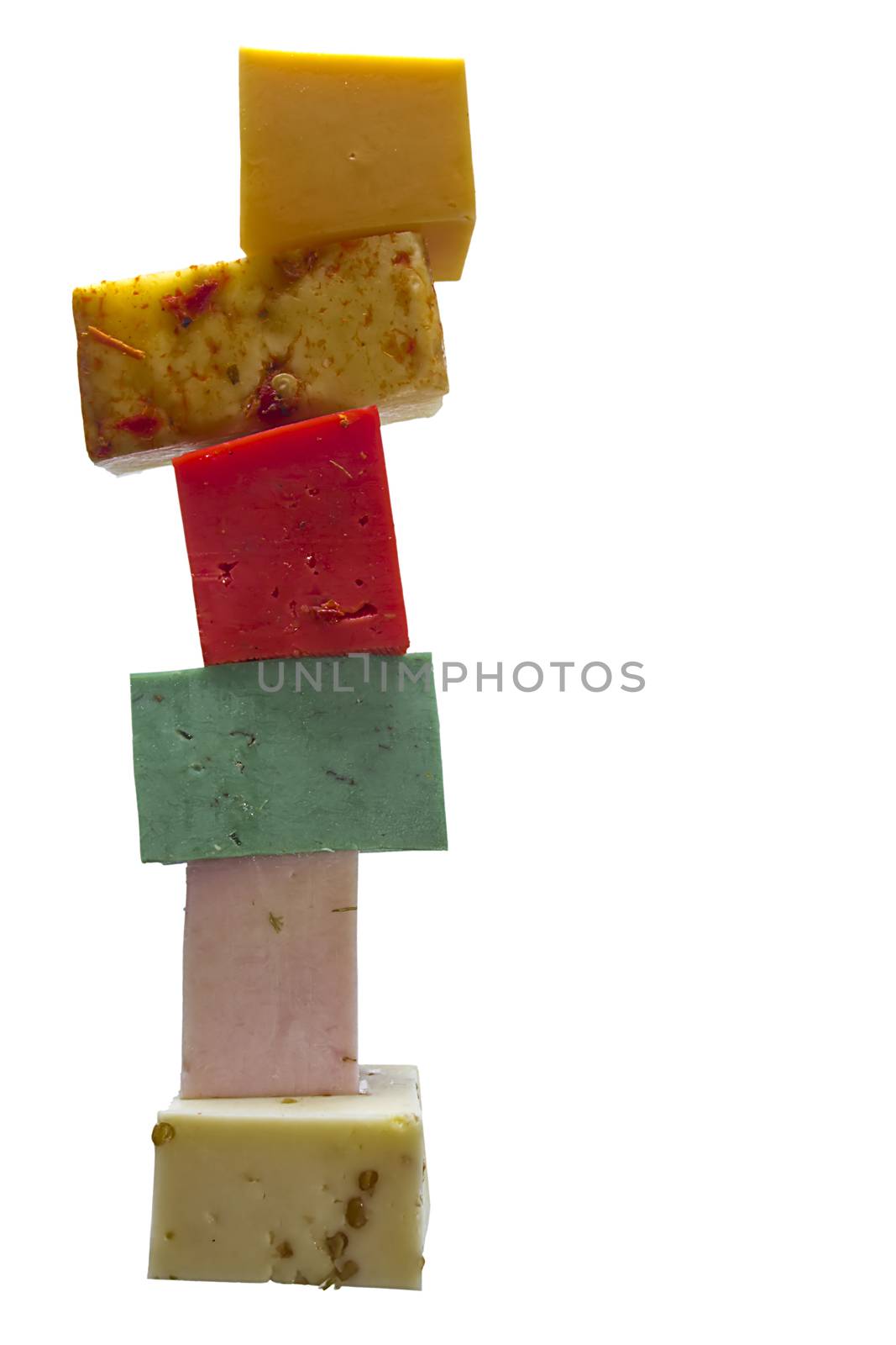 Pieces of multi-colored cheeses on a white background