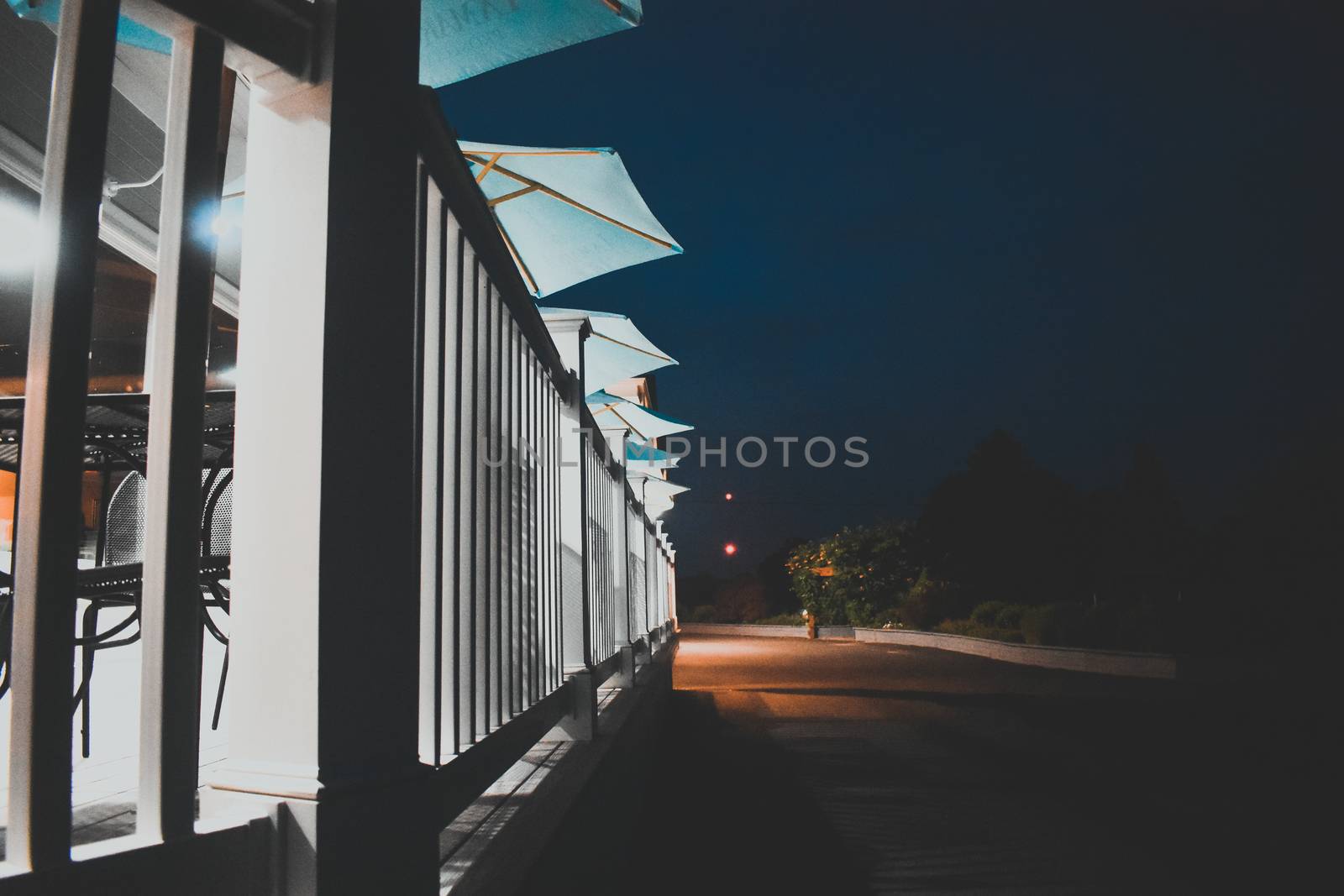 A Row of Light Blue Umbrellas on a Wooden Deck by bju12290