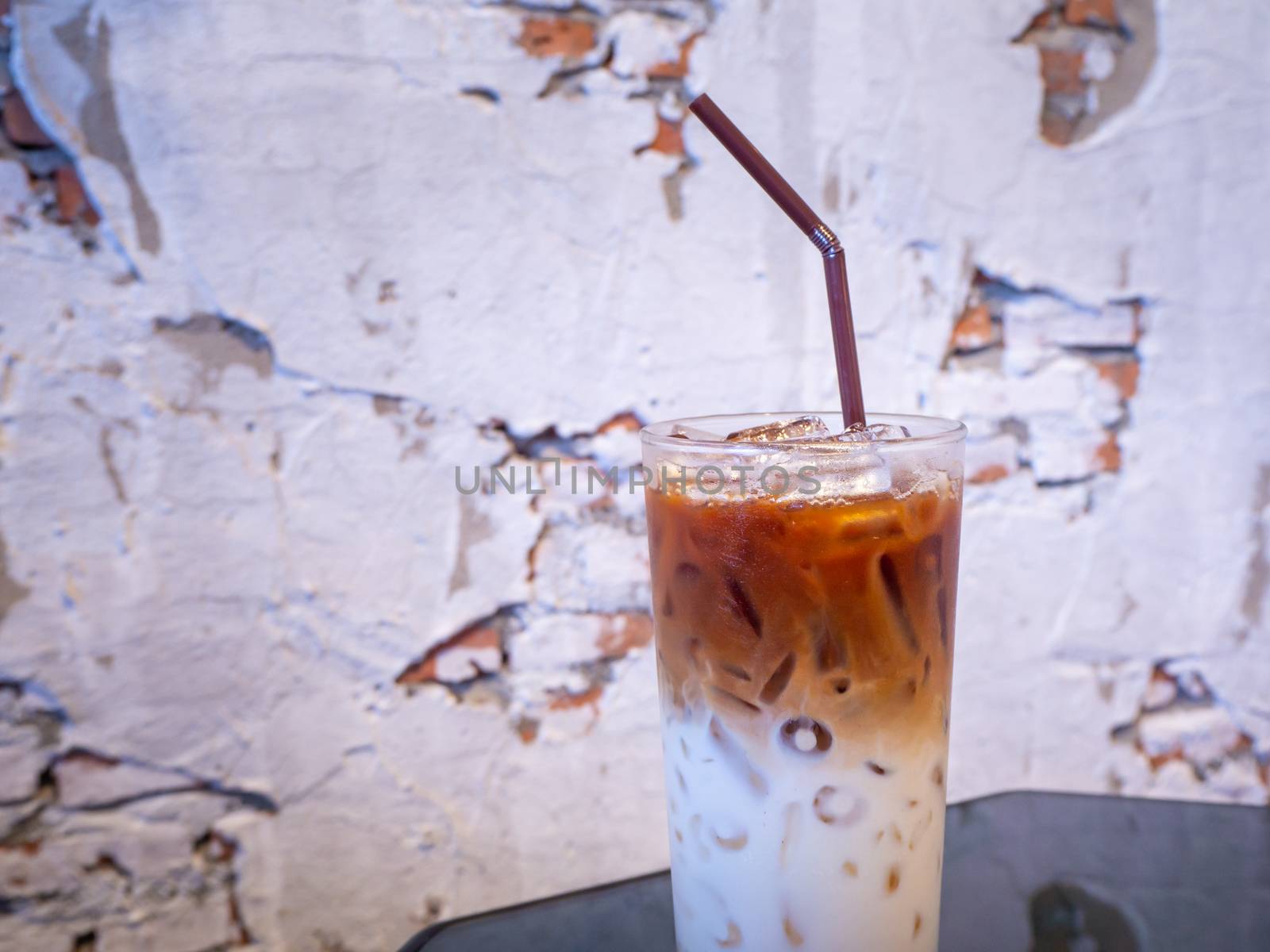 Iced latte coffee glass on wooden table  by shutterbird