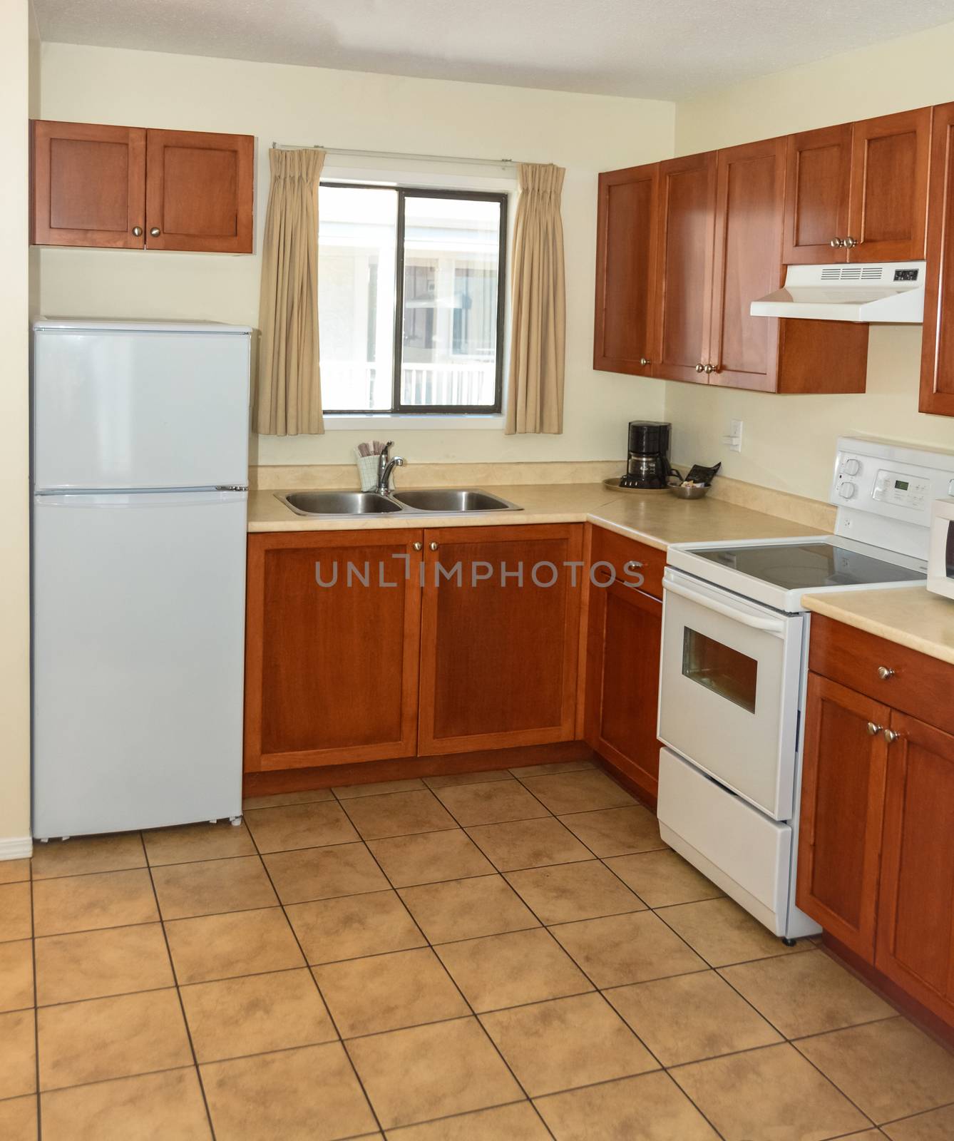 Kitchen with wooden cabinets, fridge, and electric stove