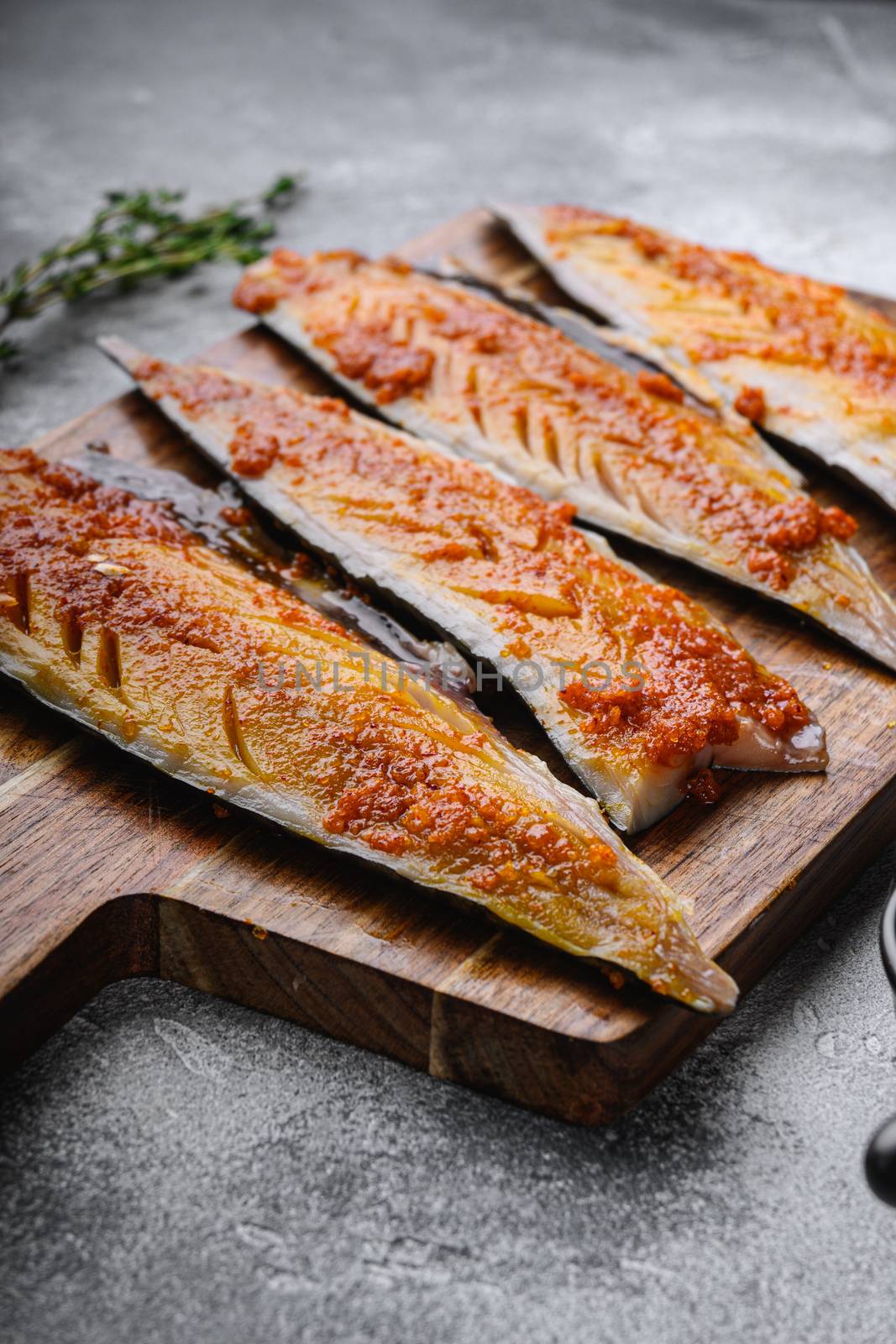 Fish fillet marinated with paprika and saffron on grey background.