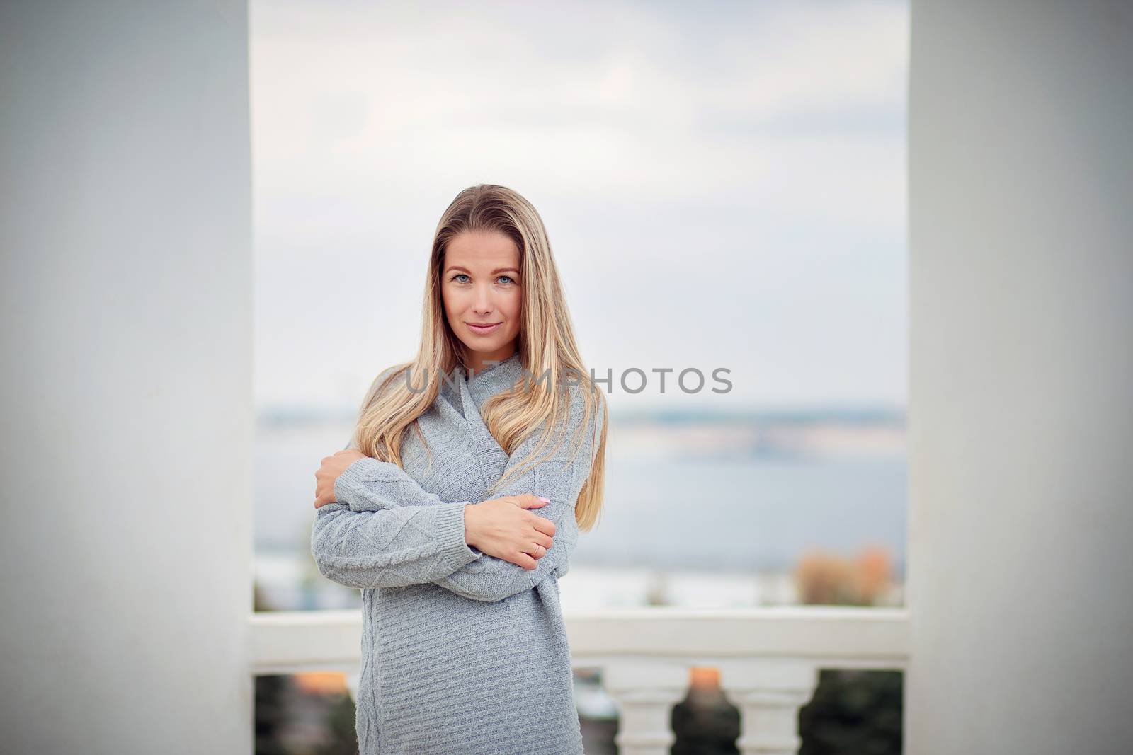 beautiful girl froze on the street and wrapped herself in her warm gray cardigan by borisenkoket