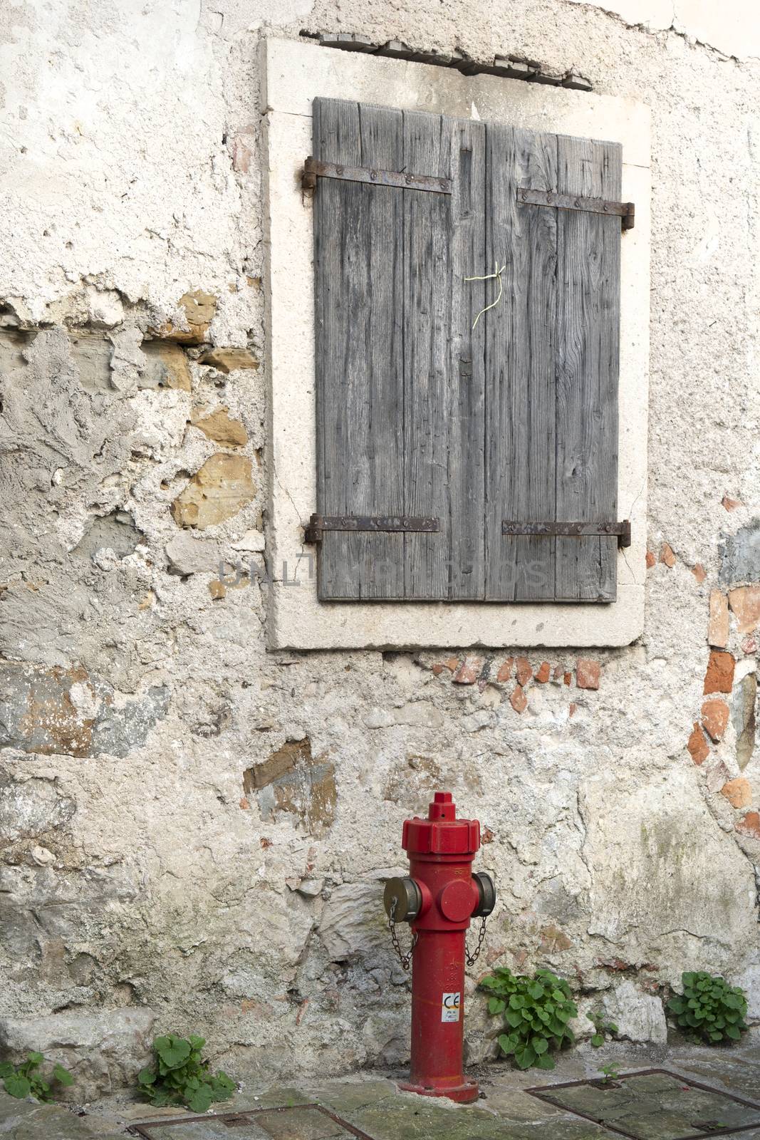 a red fire hydrant at the edge of a old street