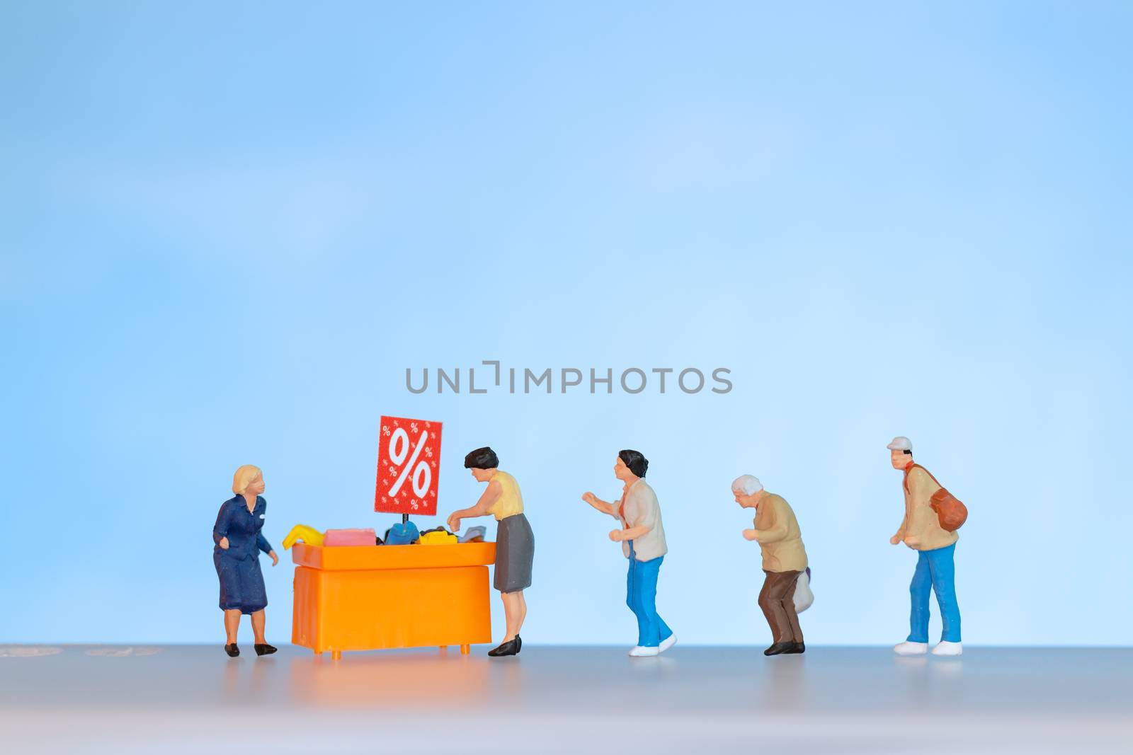 Miniature people , Shoppers with discount tray for shopping discounted items