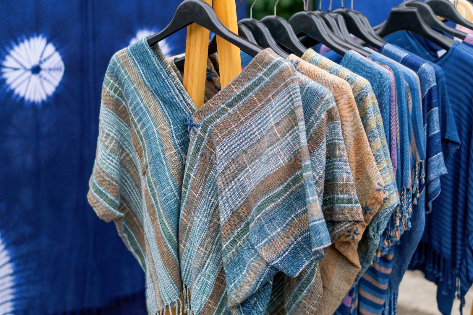 Close up T-shirt Indigo clothing is hand-woven in clothes rack at walking street, selective focus
